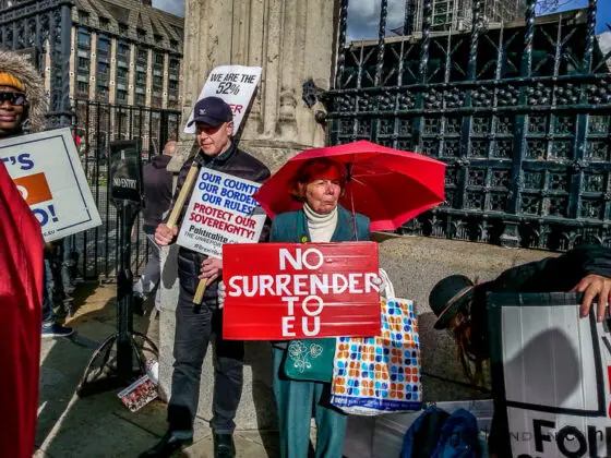 Brexit Culture: Flags and Signs Speak Out 2 Sign saying No Surrender to EU protestors parliament